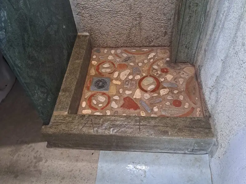 Χτιστή ντουζιέρα με δάπεδο από ψηφιδωτό με βότσαλα